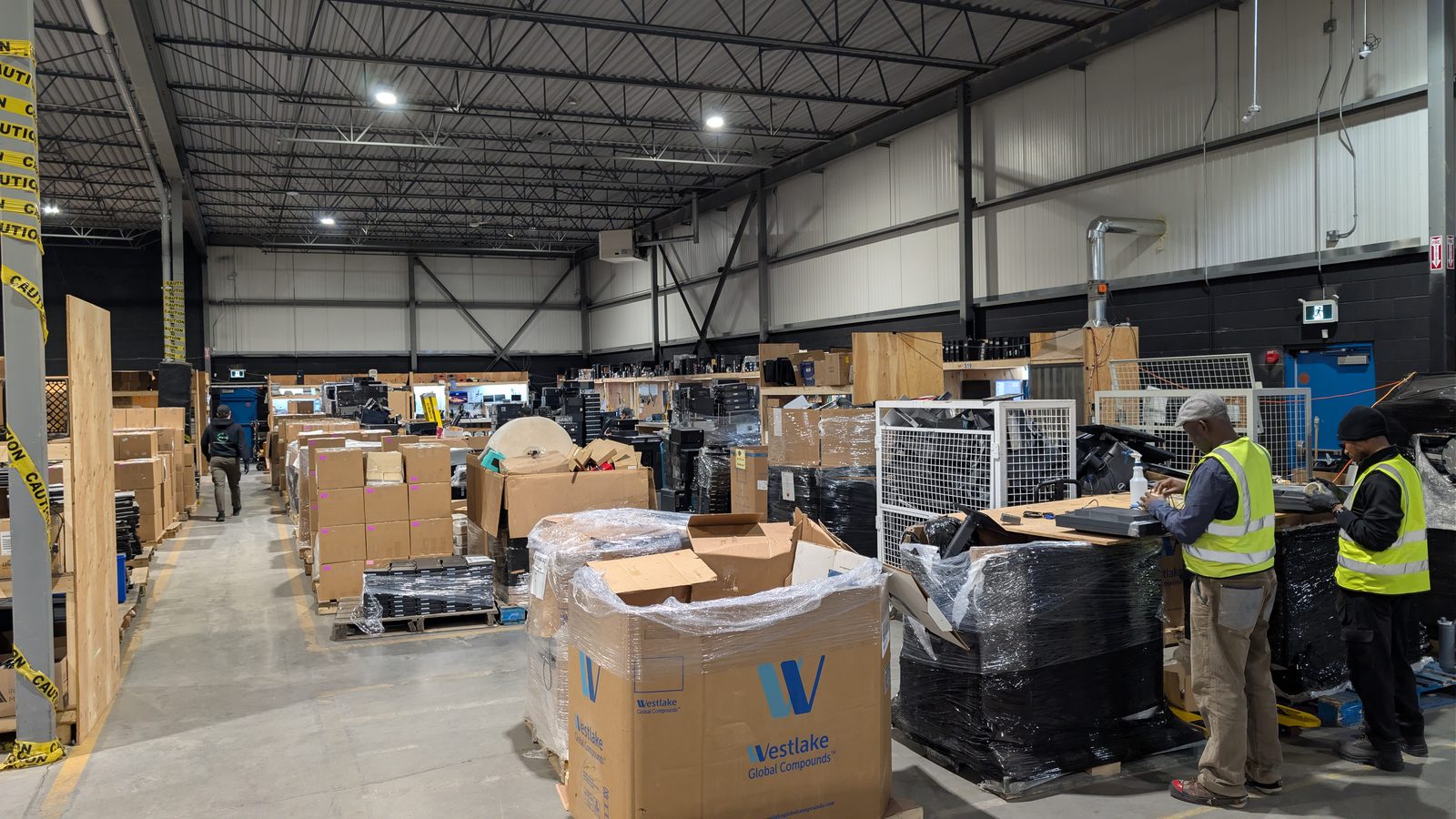 ERA staff in safety vests handling palleted enterprise equipment in the warehouse