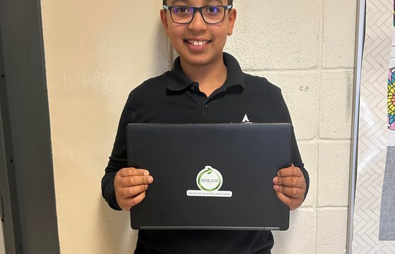 Student holding a donated ERA laptop