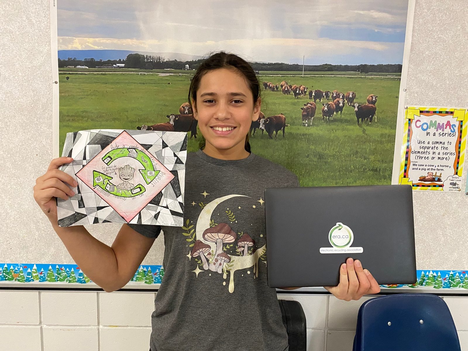 Student with a refurbished ERA laptop and her award-winning classroom poster